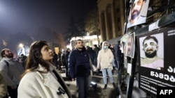 Tbilisidə gürcü polisi tərəfindən döyüldüyü bildirilən insanları əks etdirən plakatlar.